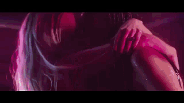 two women are kissing each other in a dark room .