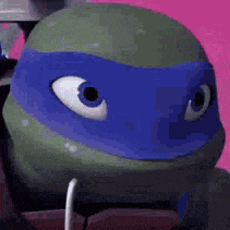 a close up of a teenage mutant ninja turtle with a blue mask on his face .