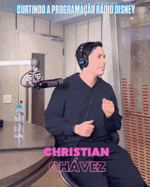 a man wearing headphones is sitting in front of a microphone with the name christian chavez on the bottom right