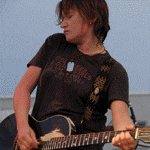 a person playing a guitar with a shirt that says ' converse ' on it