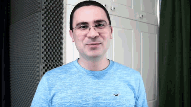 a man wearing glasses and a blue shirt with an eagle on the front