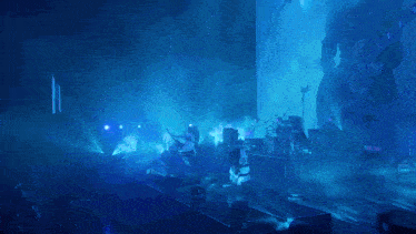 a man is playing a guitar on a stage with blue lights