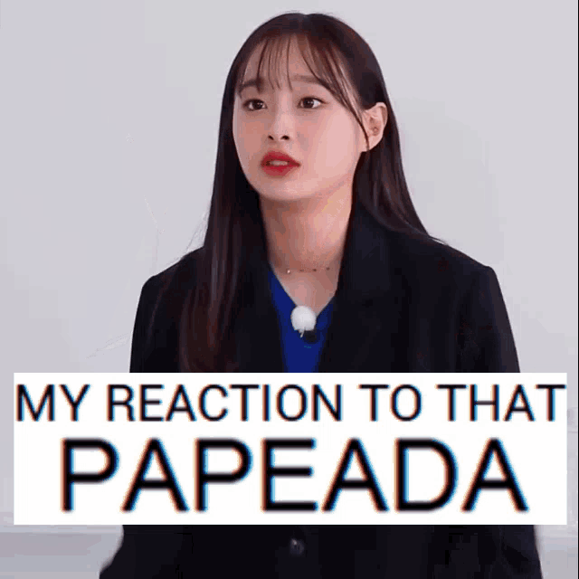 a woman in a suit stands in front of a sign that says " my reaction to that papeada "