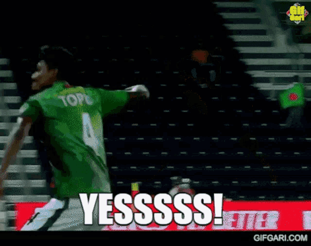 a man in a green jersey says yesssss in front of empty bleachers