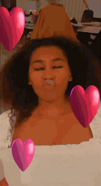 a girl blowing a kiss with hearts around her