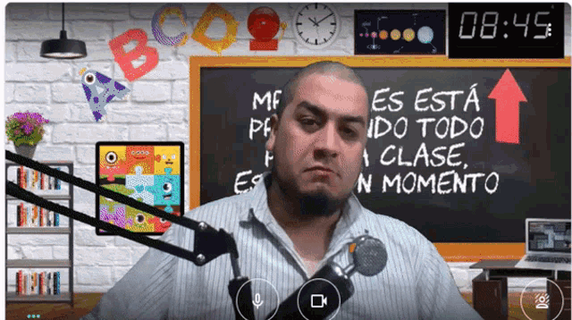 a man stands in front of a chalkboard that says es esta ido todo clase en momento