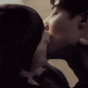 a man and a woman are kissing and the woman is touching the man 's neck