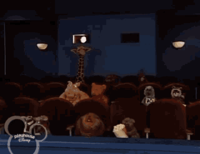 a group of stuffed animals are watching a movie at the playhouse disney