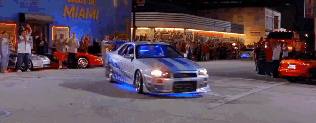a car is driving down a street in front of a building that says miami on it