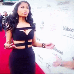 a woman stands on a red carpet in front of a billboard
