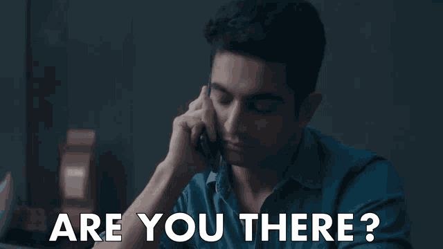 a man holding a cell phone with the words " are you there " written below him