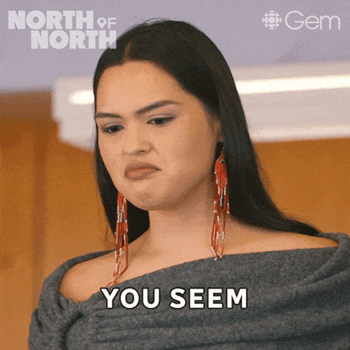 a woman making a face and saying you seem in front of a poster for north of north