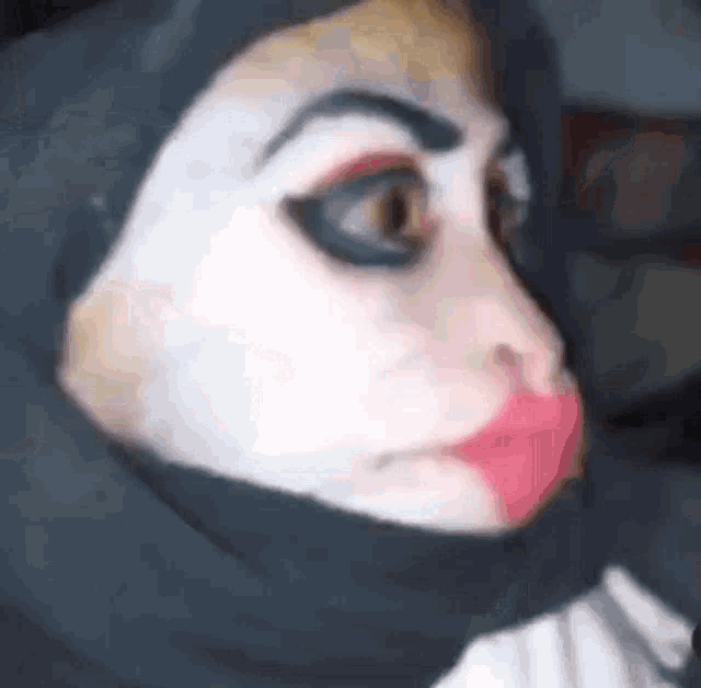 a close up of a person 's face with makeup and a black hijab .