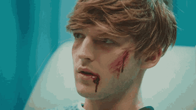 a man with blood coming out of his mouth is sitting in a hospital bed