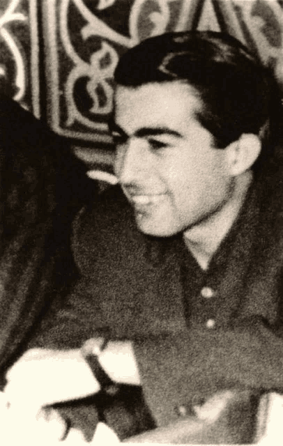 a man with a cigarette in his mouth is smiling in a black and white photo