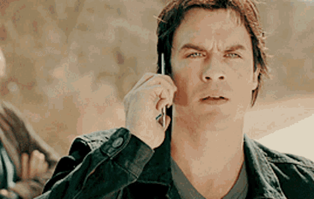a man is talking on a cell phone and making a funny face