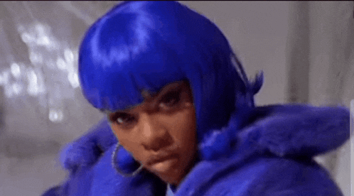 a woman wearing a blue wig and a blue fur coat is making a funny face .
