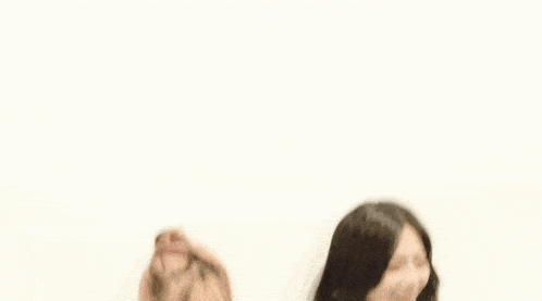 a couple of girls standing next to each other with chinese writing on the bottom
