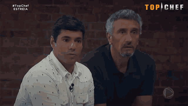 two men are sitting in front of a brick wall with the words top chef on the bottom