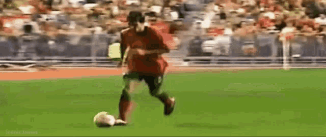 a soccer player is kicking a soccer ball on a field .