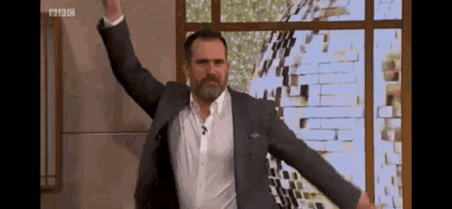 a man in a suit is dancing on a television show
