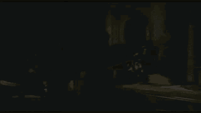 a shadow of a person is cast on a dark floor