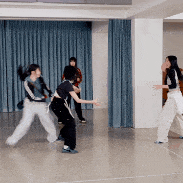 a group of girls are dancing in a dance studio