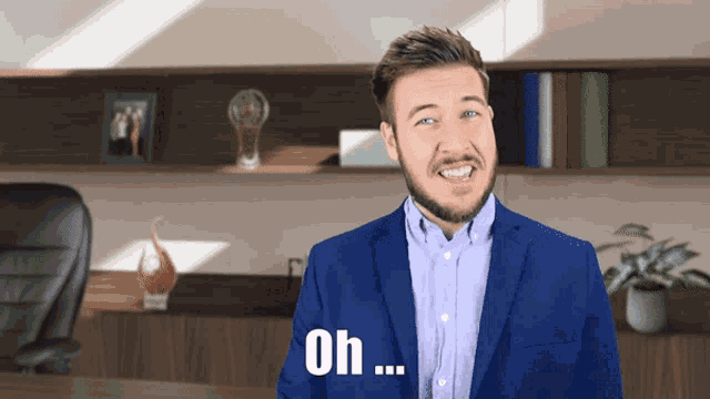 a man in a blue suit says oh in front of his face