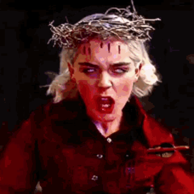 a woman wearing a crown of thorns and a red jacket
