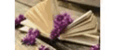 a fan with purple flowers on it is sitting on a table .