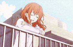 a girl with red hair is leaning on a railing and smiling