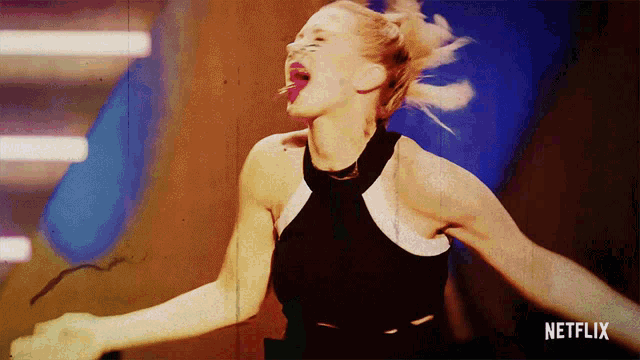 a woman is dancing in front of a netflix ad