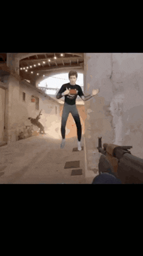 a man is jumping in the air in a video game with a gun behind him