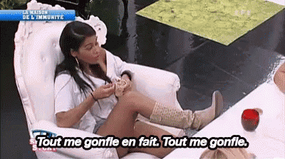 a woman is sitting in a chair with her legs crossed and says tout me gonfle en fait
