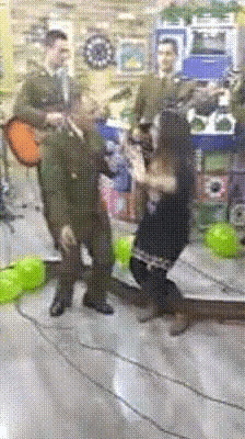 a man is playing a guitar while a woman is dancing