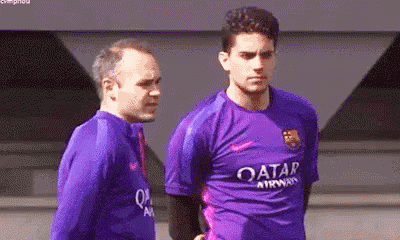 two men are standing next to each other and one of them is wearing a purple shirt that says qatar airways .