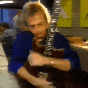 a blurry image of a man playing a guitar