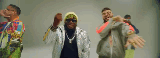 a group of men are dancing together and one of them is wearing sunglasses and a beanie
