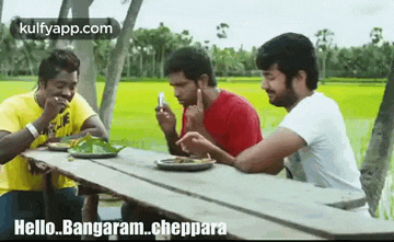 a group of men are sitting at a picnic table eating food .