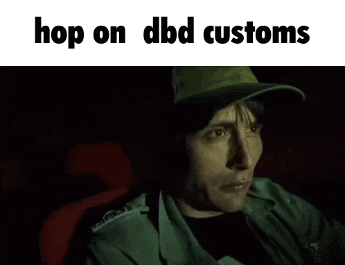a man wearing a green hat is sitting in a dark room with the words hop on dbd customs above him