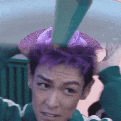 a man with purple hair is wearing a green and white shirt