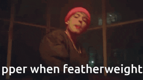 a man in a red hat is standing in a dark room with the words pper when featherweight written on the bottom .