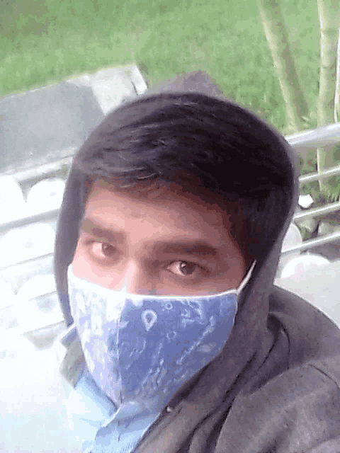 a man wearing a face mask and a hoodie