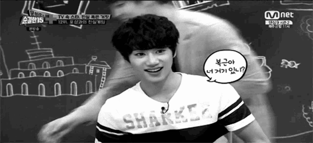 a black and white photo of a boy wearing a shark shirt