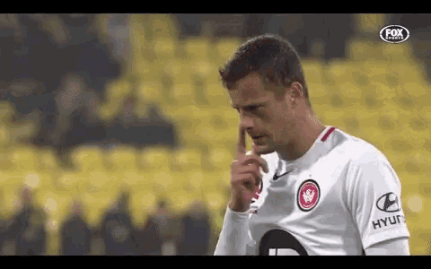 a soccer player wearing a white shirt with hyundai on the sleeve