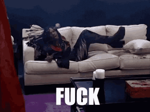 a person laying on a couch with the word fuck written on the floor