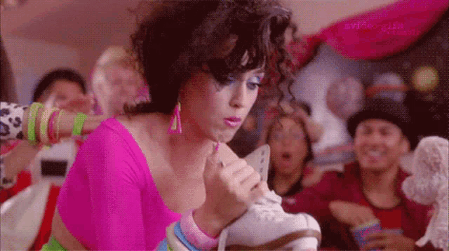a woman in a pink top holds a pair of roller skates in her hand