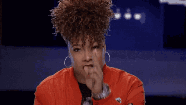 a woman with curly hair is saying `` stay focused '' while pointing at the camera .