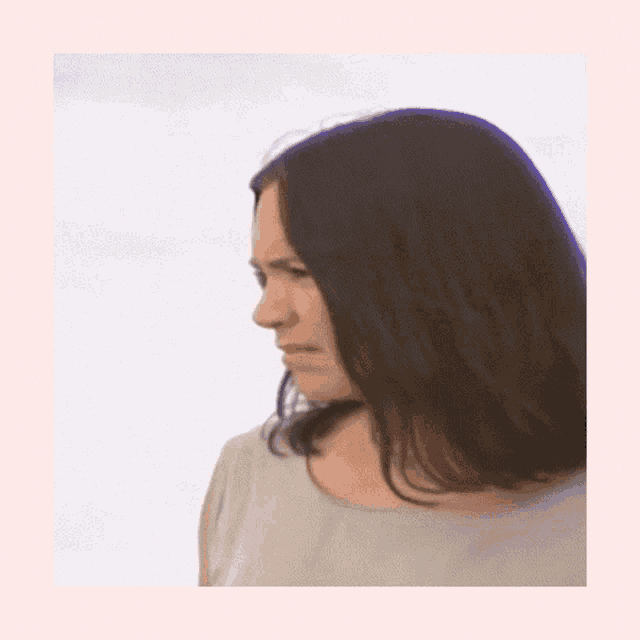 a woman with long brown hair is wearing a white top