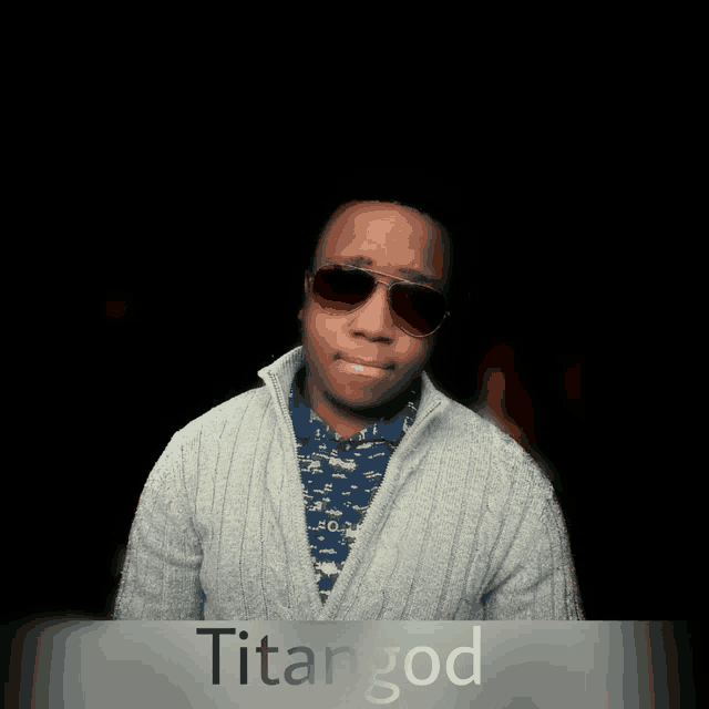 a man wearing sunglasses and a sweater with the name titangod on the bottom right